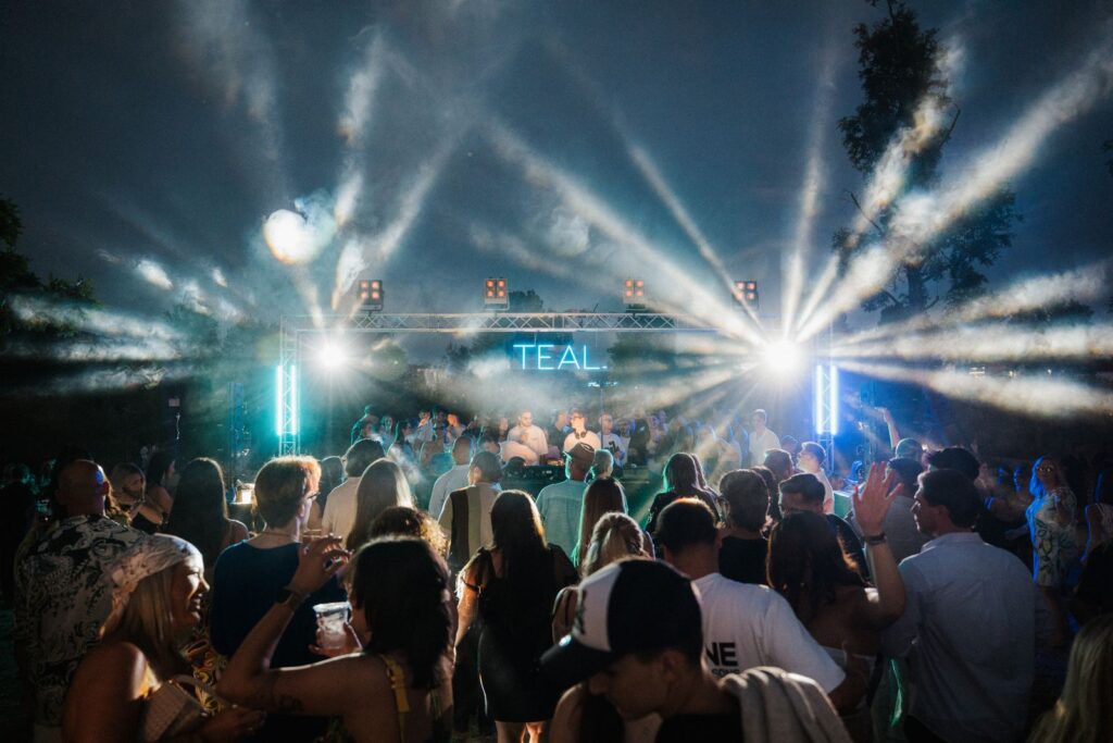 Crowd bei der TEAL. Dayparty auf dem BUGA-Gelaende mit dramatischen Lichtstrahlen